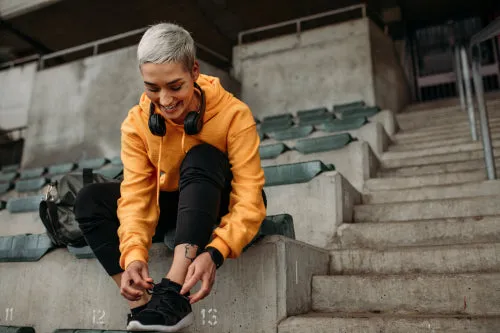 Cheerful female athlete wearing her shoes